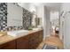 A well-lit main bathroom boasts a double sink vanity and tiled backsplash, adjacent to the main bedroom at 14131 Islamorada Dr, Orlando, FL 32837