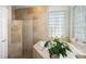 This bathroom features an enclosed shower and standalone tub with natural light from a glass block window at 14131 Islamorada Dr, Orlando, FL 32837