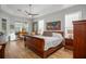 Spacious main bedroom features a wooden bed frame, a ceiling fan, and multiple windows providing natural light at 14131 Islamorada Dr, Orlando, FL 32837