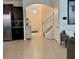 Open entryway with tile flooring, featuring stairs with white railing, and access to the kitchen and living areas at 16391 Admirals Cove Ln, Winter Garden, FL 34787