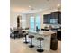 Modern kitchen features a breakfast bar with granite countertops, stainless steel appliances, and dark cabinetry with lots of natural light at 16391 Admirals Cove Ln, Winter Garden, FL 34787
