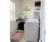 Organized laundry room with modern washer/dryer, storage, and a cozy dog bed for added comfort at 16391 Admirals Cove Ln, Winter Garden, FL 34787