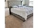 Main bedroom showcases a large tufted headboard bed, neutral carpet, a side table, and a window for lots of natural light at 16391 Admirals Cove Ln, Winter Garden, FL 34787