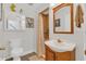 Well-lit bathroom with a vanity, mirror, toilet, and a shower with neutral color tile at 1642 Windsor Oak Ct, Kissimmee, FL 34744