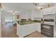 Open kitchen with white cabinets, stainless steel appliances, and natural light from the adjacent living area at 1642 Windsor Oak Ct, Kissimmee, FL 34744