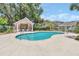 Community pool and cabana area surrounded by lush landscaping at 1642 Windsor Oak Ct, Kissimmee, FL 34744