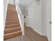Bright entryway with wooden staircase and sleek, light-colored, modern hardwood flooring at 1642 Windsor Oak Ct, Kissimmee, FL 34744