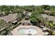 Aerial view of the community pool surrounded by lush landscaping and multi-story buildings at 184 Sandlewood Trl # 2, Winter Park, FL 32789