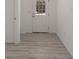This entryway has a light wood floor and a white door with window panes at 1900 Sw 178Th Street Rd, Ocala, FL 34473