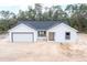 Newly constructed single-story home features a attached garage, contrasting window frames and neutral color palette at 1900 Sw 178Th Street Rd, Ocala, FL 34473