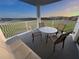Spacious balcony with metal table and chairs offering peaceful views of lush greenery and landscape at 225 Celebration Pl # 527, Kissimmee, FL 34747