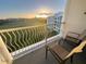 Tranquil balcony featuring lounge chairs and peaceful views of the sunrise over the neighboring green spaces at 225 Celebration Pl # 527, Kissimmee, FL 34747