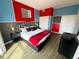 Eclectic bedroom with vibrant red and blue walls, a plush king bed, and modern furnishings providing a bold, playful space at 225 Celebration Pl # 527, Kissimmee, FL 34747