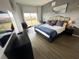 Modern bedroom with large window, grey accent wall, king bed with plush pillows, desk, chair, and wood-look flooring at 225 Celebration Pl # 527, Kissimmee, FL 34747