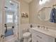 Elegant powder room with modern vanity, decorative mirror, and stylish tile flooring leading into the office at 242 W Lyman Ave, Winter Park, FL 32789