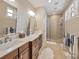 Bright bathroom with double vanity, elegant countertops, walk-in glass shower, and warm neutral tones at 242 W Lyman Ave, Winter Park, FL 32789
