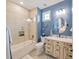 Bright bathroom featuring blue walls, a glass-enclosed tub/shower, and an ornate wooden vanity at 242 W Lyman Ave, Winter Park, FL 32789
