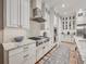 Updated kitchen with a stainless cooktop, modern range hood, granite countertops and custom cabinetry at 242 W Lyman Ave, Winter Park, FL 32789