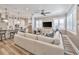 Spacious living room featuring hardwood floors, large windows with shutters, and a comfortable, oversized couch at 242 W Lyman Ave, Winter Park, FL 32789
