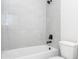 Close-up of tiled shower and tub with matte black fixtures in bathroom at 25 W 7Th St, Apopka, FL 32703