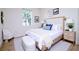 Serene bedroom featuring a light wood bed with white bedding, side tables, lamps, and a stylish decor at 25 W 7Th St, Apopka, FL 32703