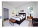 Stylish bedroom featuring a black bed with decorative pillows, side tables, lamps, and natural lighting at 25 W 7Th St, Apopka, FL 32703