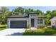 Beautiful single-story home featuring a gray exterior, dark gray garage door, and neatly landscaped front yard at 25 W 7Th St, Apopka, FL 32703