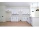 Modern kitchen featuring white cabinets, a stylish backsplash, stainless steel appliances, and light wood flooring at 25 W 7Th St, Apopka, FL 32703