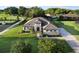 Expansive home showcasing its beautiful landscaping, stone accents, paver driveway, and tiled roof at 25859 Crossings Bluff Ln, Sorrento, FL 32776