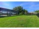 A spacious backyard with a screened-in pool area, ideal for outdoor activities and relaxation at 25859 Crossings Bluff Ln, Sorrento, FL 32776