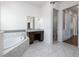 Bright primary bathroom featuring a vanity, soaking tub, and an arched doorway with private water closet at 25859 Crossings Bluff Ln, Sorrento, FL 32776