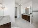 Bathroom showcasing double vanity, chandelier lighting, and tiled shower at 25859 Crossings Bluff Ln, Sorrento, FL 32776