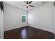 Well-lit bedroom with dark wood floors, neutral walls, a ceiling fan, and window with privacy blinds at 25859 Crossings Bluff Ln, Sorrento, FL 32776