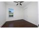 Bright bedroom with dark wood floors, closet with sliding doors, a ceiling fan, and window with privacy blinds at 25859 Crossings Bluff Ln, Sorrento, FL 32776