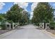 Scenic entrance to Crossings Bluff with white gates, stone pillars, and tree-lined street at 25859 Crossings Bluff Ln, Sorrento, FL 32776