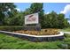 Red Tail community sign surrounded by colorful flowers and lush greenery at 25859 Crossings Bluff Ln, Sorrento, FL 32776