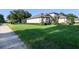 Single-Gathering house with lush green lawn and manicured landscaping at 25859 Crossings Bluff Ln, Sorrento, FL 32776