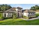 Inviting home featuring stone accents, lush landscaping, and a well-manicured lawn at 25859 Crossings Bluff Ln, Sorrento, FL 32776