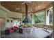 Outdoor gathering place featuring a stone fireplace, seating, and views of the greenery at 25859 Crossings Bluff Ln, Sorrento, FL 32776