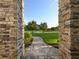 Inviting entryway featuring stone pillars and a brick walkway leading to a beautifully landscaped front yard at 25859 Crossings Bluff Ln, Sorrento, FL 32776