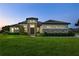 Beautiful single-story home featuring stone accents, a well-manicured lawn, and mature landscaping at 25859 Crossings Bluff Ln, Sorrento, FL 32776