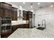 Modern kitchen with stainless steel appliances, granite countertops, dark wood cabinetry, and open to dining area at 25859 Crossings Bluff Ln, Sorrento, FL 32776