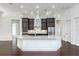 Gourmet kitchen featuring a large island, stainless steel appliances, dark wood cabinetry, and modern lighting at 25859 Crossings Bluff Ln, Sorrento, FL 32776