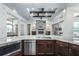 Open-concept kitchen with stone fireplace feature, stainless steel appliances, and a seamless flow into the living area at 25859 Crossings Bluff Ln, Sorrento, FL 32776