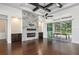 Bright living room featuring a stone fireplace, dark wood floors, and sliding glass doors at 25859 Crossings Bluff Ln, Sorrento, FL 32776
