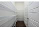 Walk-in pantry featuring wood-look floor and ample white shelving for organized storage at 25859 Crossings Bluff Ln, Sorrento, FL 32776