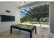 Covered patio with pool table, television, and view of swimming pool at 25859 Crossings Bluff Ln, Sorrento, FL 32776