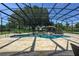 A screened-in pool with a stone waterfall feature surrounded by well-maintained landscaping at 25859 Crossings Bluff Ln, Sorrento, FL 32776