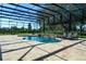 A screened-in pool with a stone waterfall feature and lounge chairs, perfect for relaxing in a private backyard at 25859 Crossings Bluff Ln, Sorrento, FL 32776