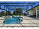 A screened-in pool area with a water feature offers a relaxing space with outdoor seating and a view of the backyard at 25859 Crossings Bluff Ln, Sorrento, FL 32776